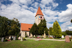 Die Kirche in der Gemeinde Neusitz mit dem Friedhof im Vordergrund