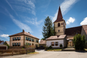 Die Kirche mit Spitzdach und das Pfarramt in der Gemeinde Ohrenbach